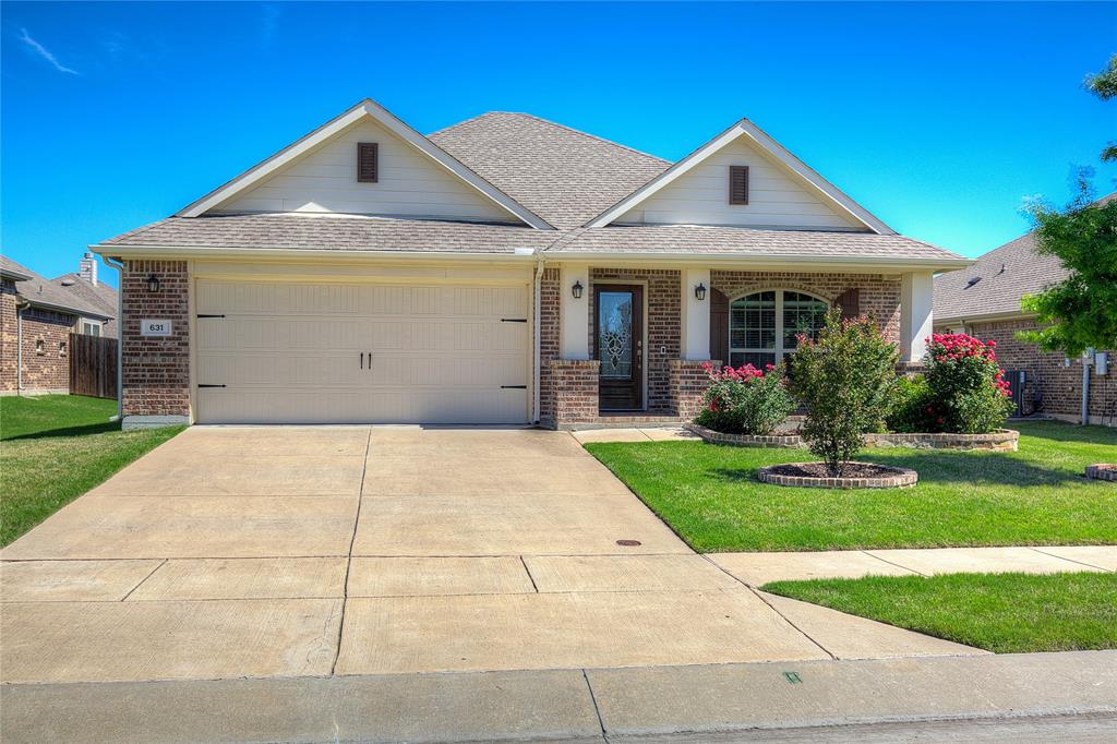 a front view of a house with a yard and potted plants