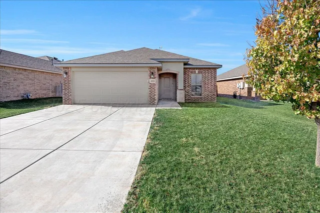 a front view of a house with a garden and yard