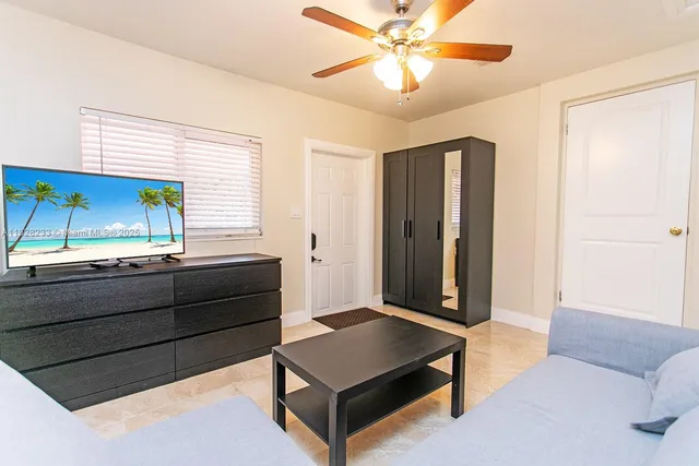 a bedroom with a bed chandelier and a window
