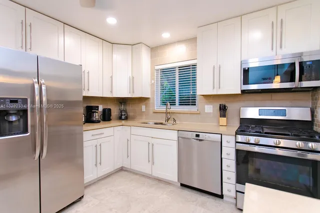 a kitchen with stainless steel appliances granite countertop a sink and stove top oven