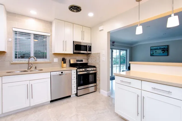 a kitchen with stainless steel appliances granite countertop a stove a microwave and cabinets