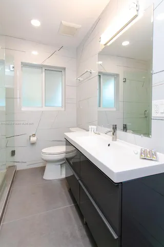 a bathroom with a toilet a sink and mirror