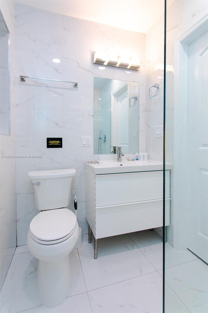 809 South 17th Avenue Hollywood, FL 33020 - Photo 42 of 45 a bathroom with a toilet a sink and mirror