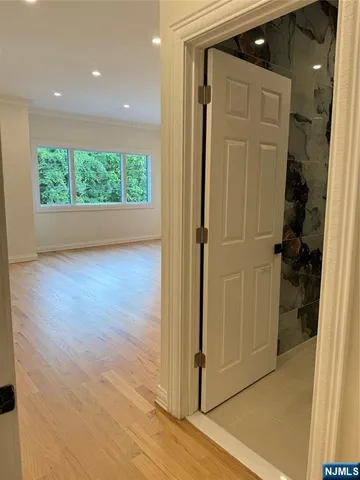 a view of a hallway with wooden floor and livingroom with furniture