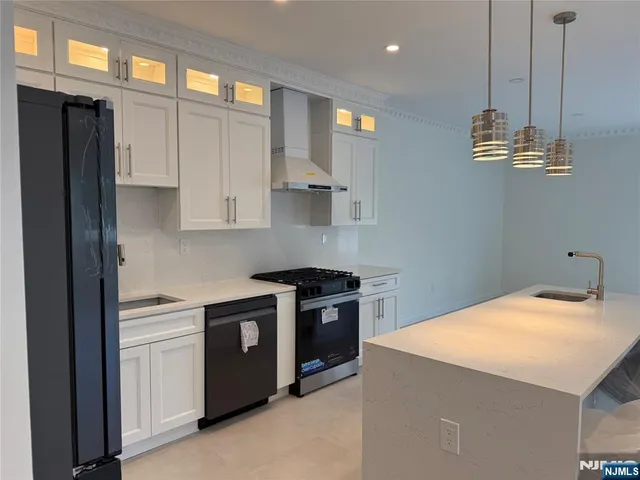 a kitchen with stainless steel appliances kitchen island a refrigerator sink and stove