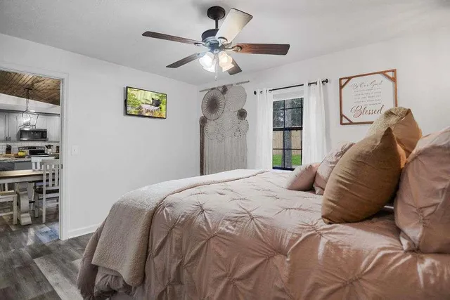 a spacious bedroom with a bed and a chandelier