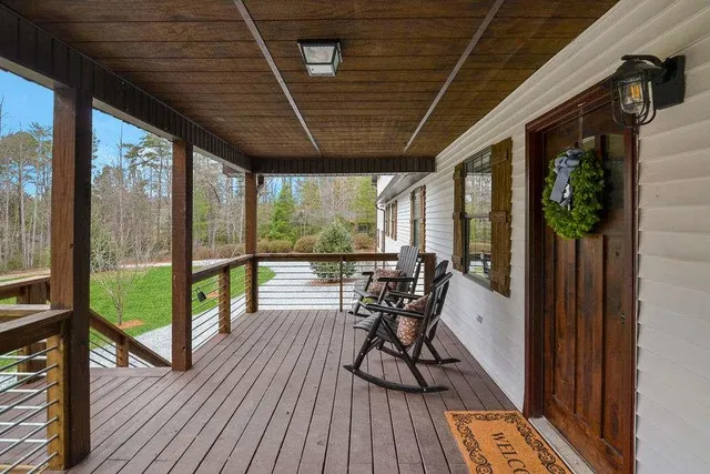 a view of a porch with furniture and wooden floor