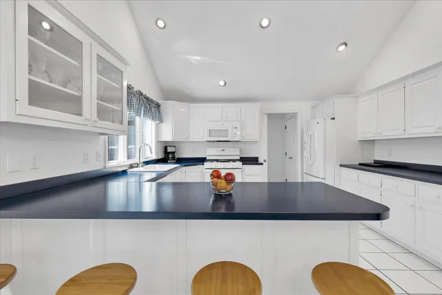 a kitchen with stainless steel appliances a refrigerator a stove a sink dishwasher a stove and a dining table with wooden floor