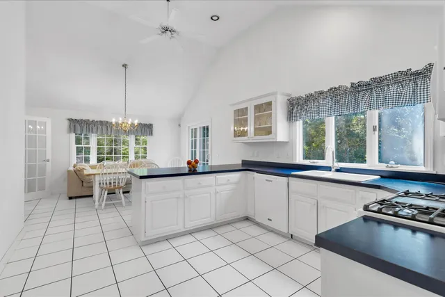 a kitchen with stainless steel appliances a stove a sink and white cabinets