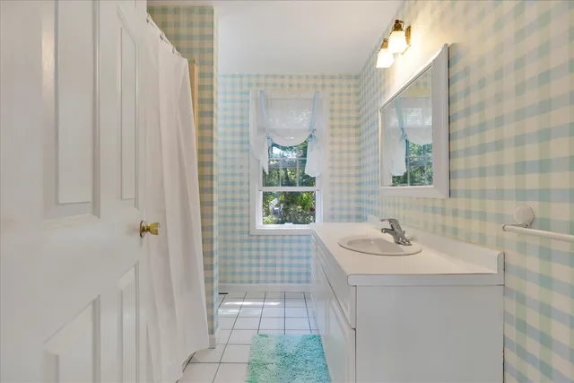 a bathroom with a sink a mirror and next to a window