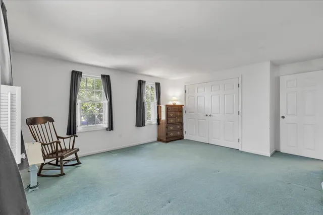 an empty room with windows and lounge chair