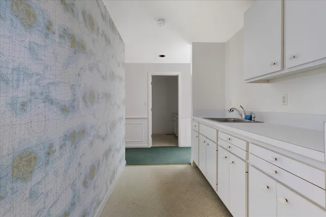 a hallway with granite countertop white cabinets