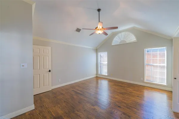 a view of an empty room with window and wooden floor