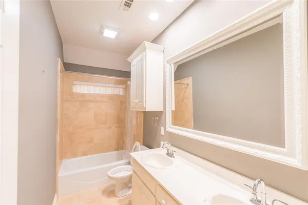 a bathroom with a granite countertop sink a toilet and shower