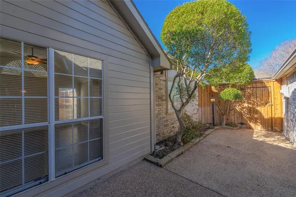 a view of a house with a small yard and wooden fence