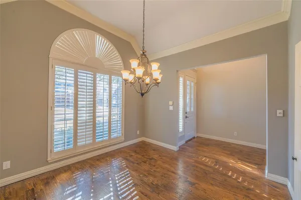 a view of a livingroom with a chandelier fan and wooden floor