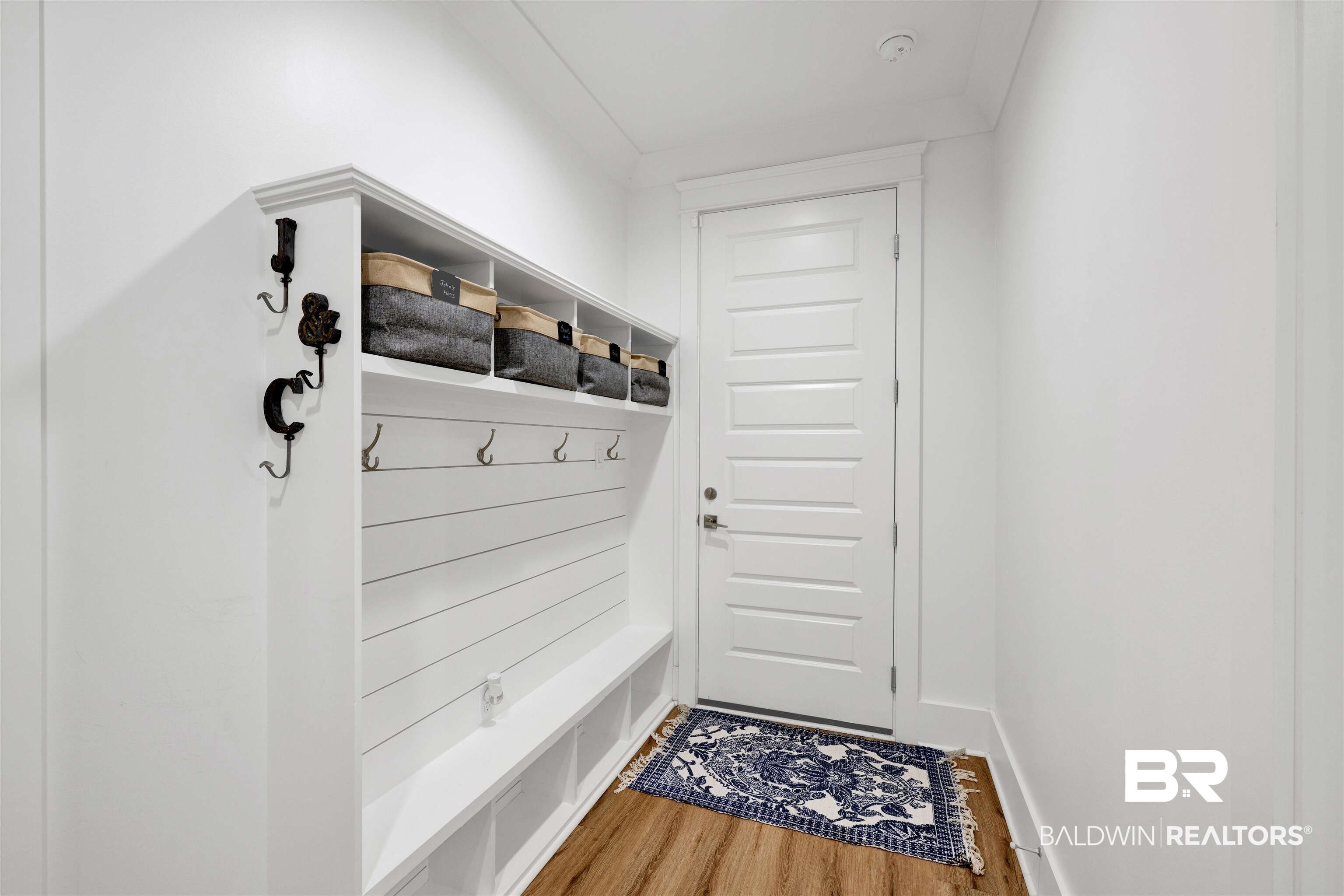 21702 Pillars Street Fairhope, AL 36532 - Photo 32 of 54 Entryway featuring built-in white shiplap bench with storage cubbies, upper shelving, and multiple coat hooks