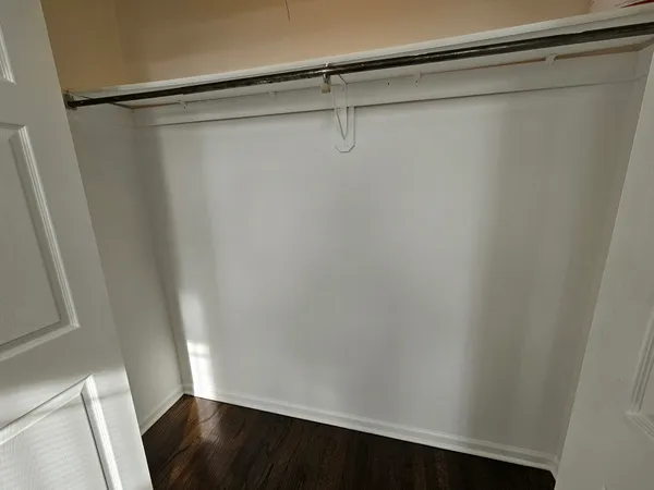 a view of a room with wooden floor and a window