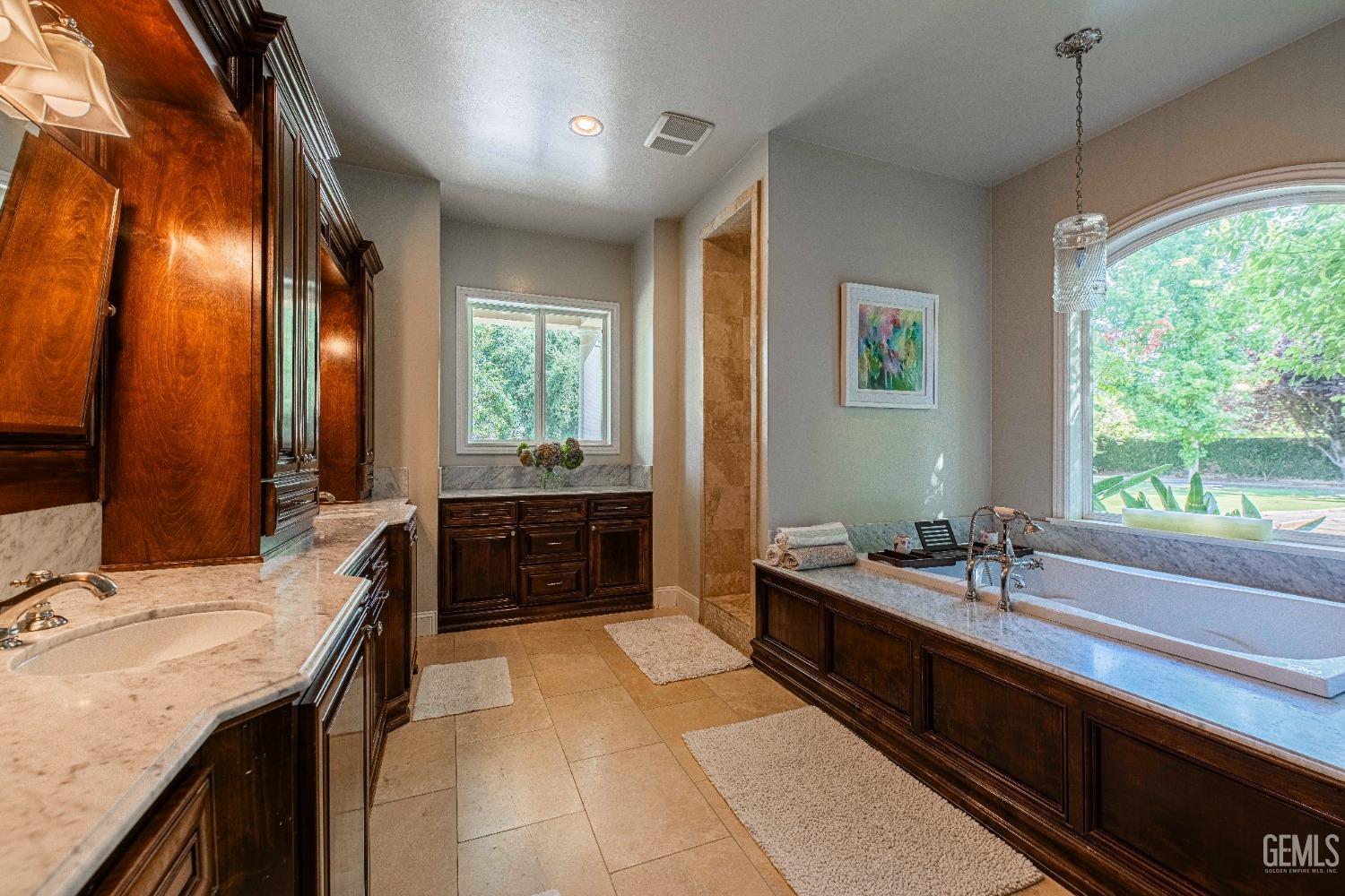 Undisclosed Address Bakersfield, CA 93314 - Photo 42 of 75 a spacious bathroom with a sink double vanity granite tub shower and mirror
