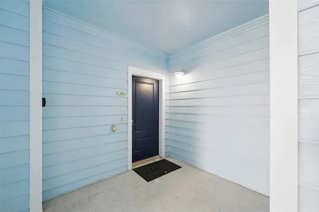 an empty room with a kitchen and entryway