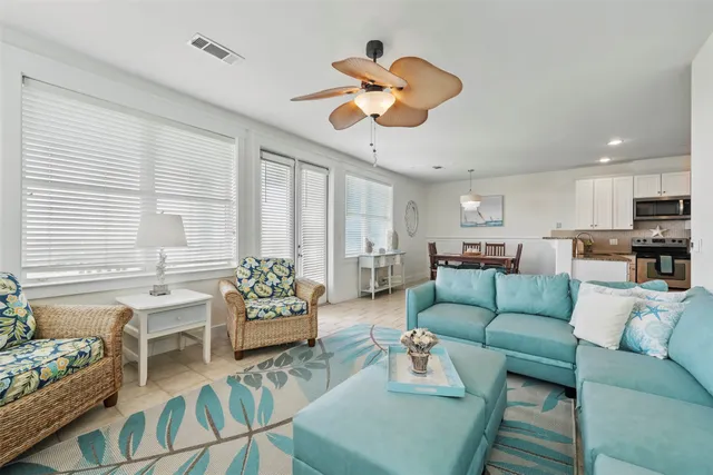 a living room with furniture kitchen view and a chandelier