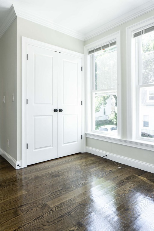 41 West Walnut Park Boston, MA 02119 - Photo 11 of 30 a view of an empty room with wooden floor and a window