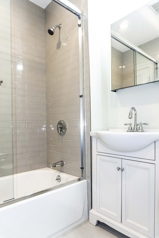 41 West Walnut Park Boston, MA 02119 - Photo 7 of 30 a bathroom with a tub a sink and mirror