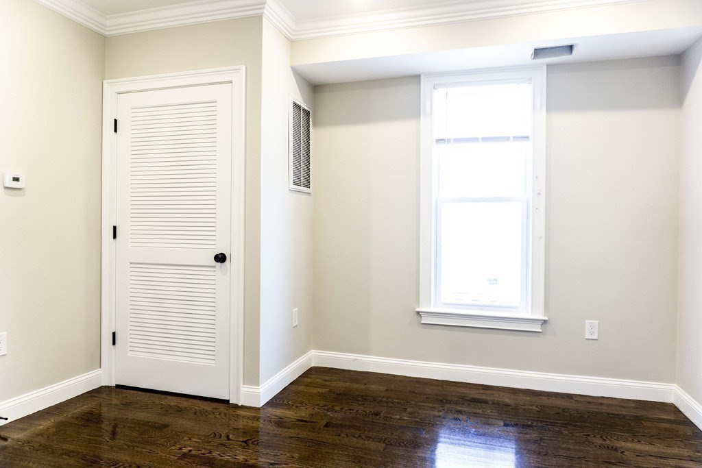 41 West Walnut Park Boston, MA 02119 - Photo 9 of 30 an empty room with wooden floor closet and windows
