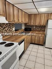 8520 Southwest 133rd Avenue Road, Unit 408 Miami, FL 33183 - Photo 3 of 10 a kitchen with a stove a sink and a refrigerator