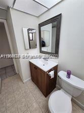 8520 Southwest 133rd Avenue Road, Unit 408 Miami, FL 33183 - Photo 7 of 10 a bathroom with a toilet sink and mirror