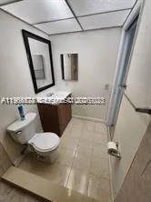 a bathroom with a granite countertop sink toilet and mirror