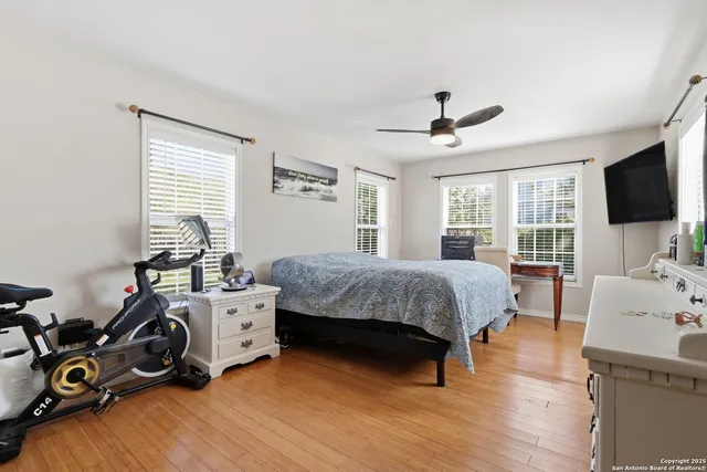 a bedroom with a bed a flat screen tv and a window