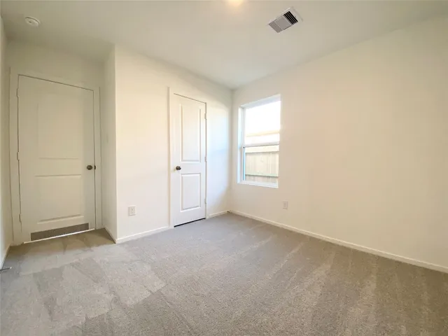 an empty room with windows and closet