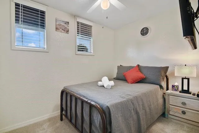 a bedroom with a bed and a flat tv screen on dresser