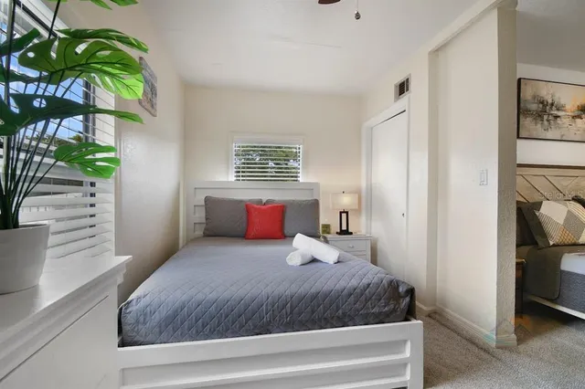 a bedroom with a bed and a potted plant