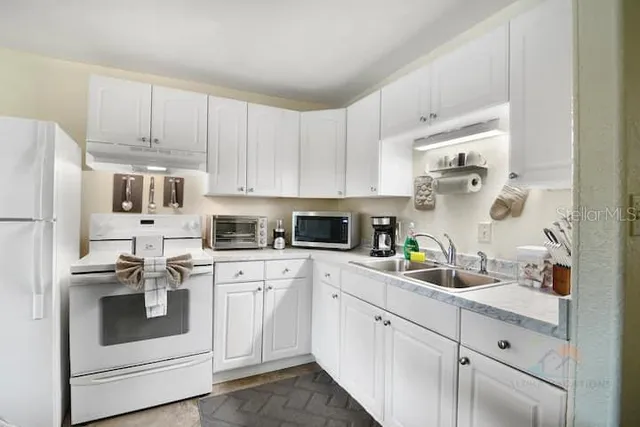 a kitchen with cabinets stainless steel appliances and a sink