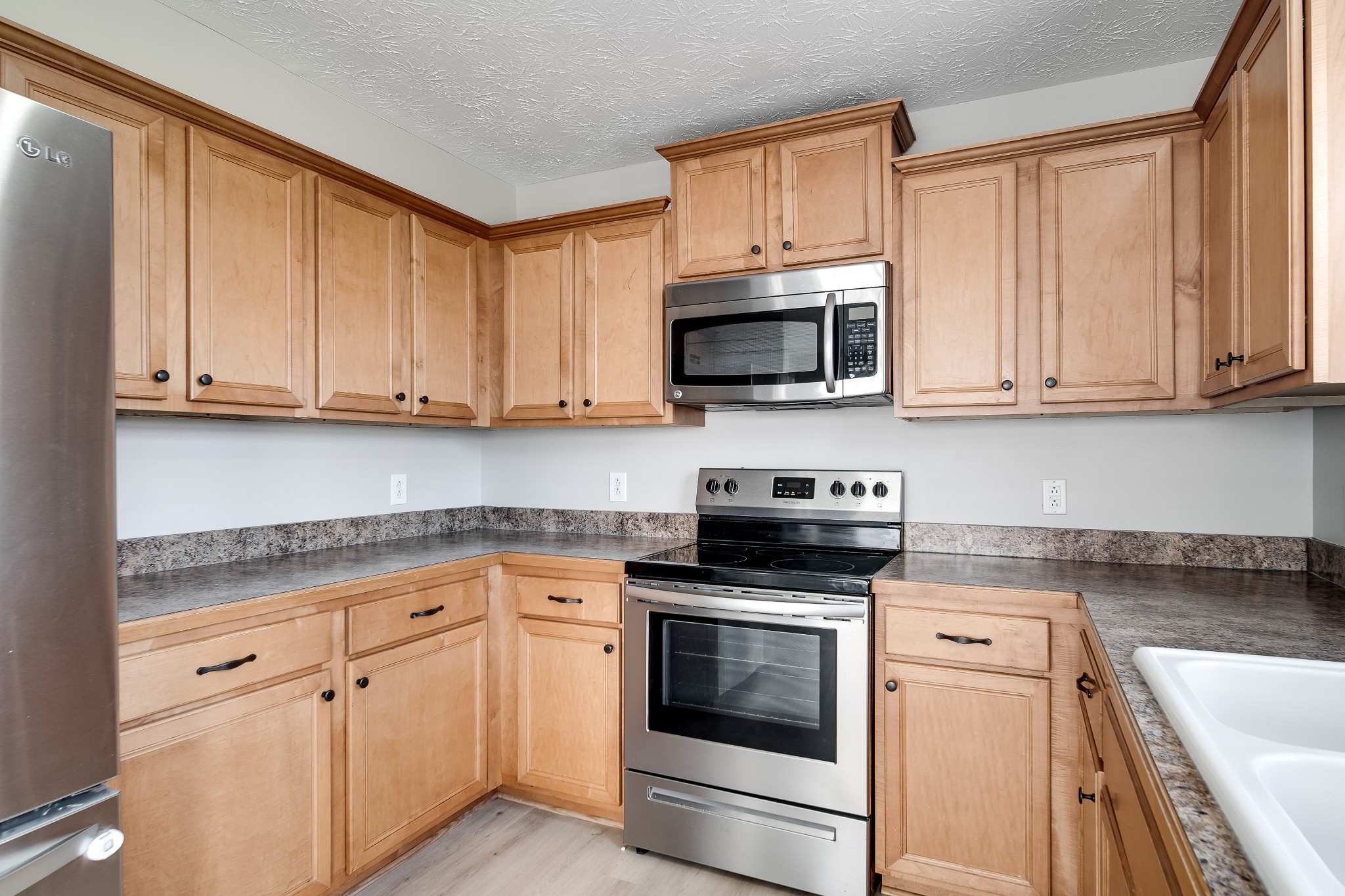 630 Berry Circle Springfield, TN 37172 - Photo 14 of 46 a kitchen with granite countertop white cabinets sink and stainless steel appliances