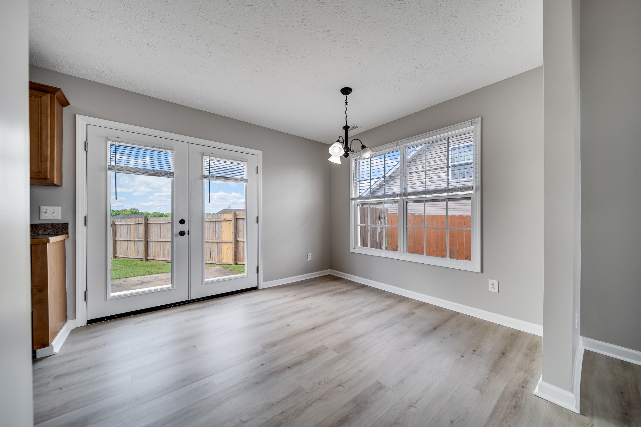 630 Berry Circle Springfield, TN 37172 - Photo 8 of 46 an empty room with wooden floor chandelier and windows