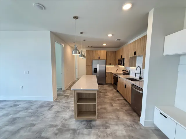 a large kitchen with white cabinets and stainless steel appliances