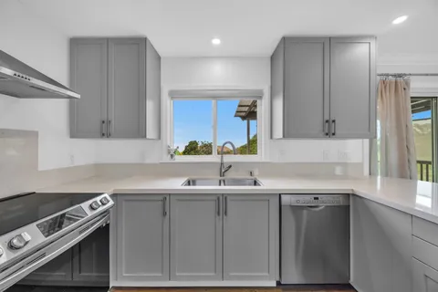 a kitchen with stainless steel appliances granite countertop a sink stove and cabinets