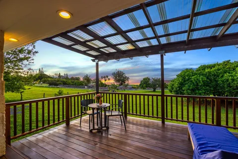 a view of a balcony with wooden floor and outdoor seating