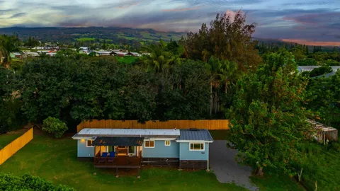 an aerial view of a house with swimming pool and garden
