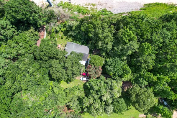 an aerial view of residential house with outdoor space and trees all around