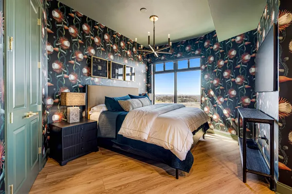 a spacious bedroom with a bed and a chandelier