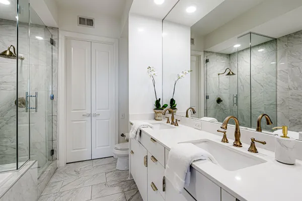 a bathroom with a double vanity sink mirror and shower