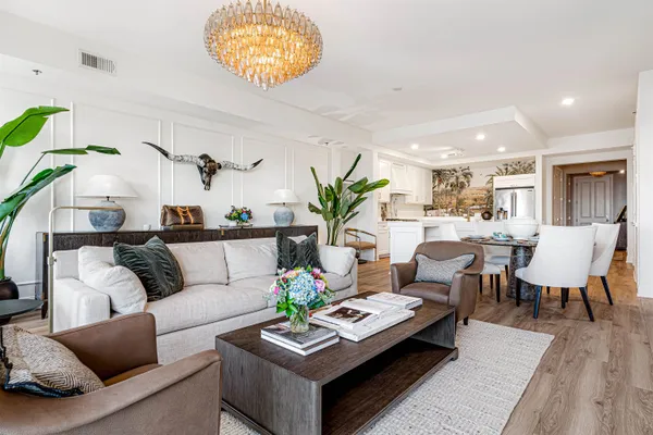 a living room with furniture kitchen view and a table