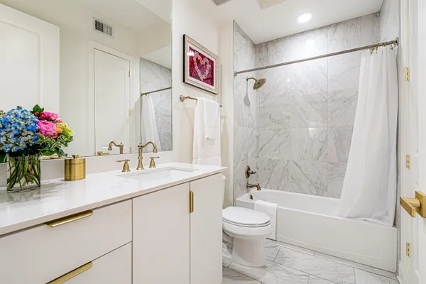 a bathroom with a shower sink vanity mirror and toilet