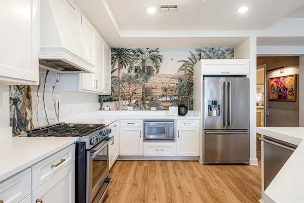 a kitchen with granite countertop a refrigerator and a stove top oven