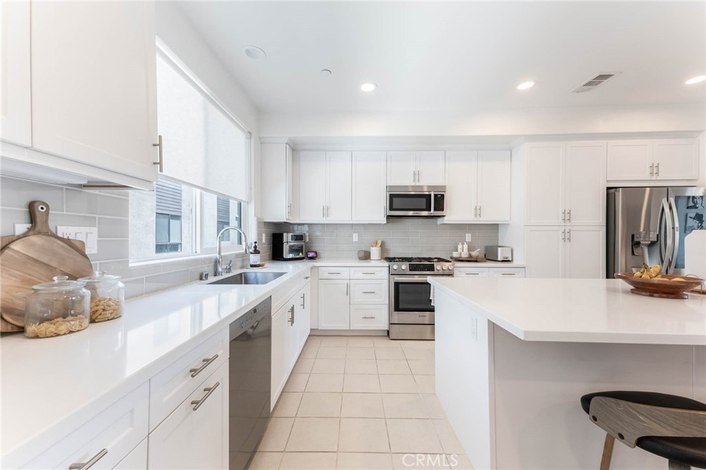 13161 Victory Boulevard Valley Glen, CA 91401 - Photo 12 of 33 a kitchen with a sink white cabinets and stainless steel appliances