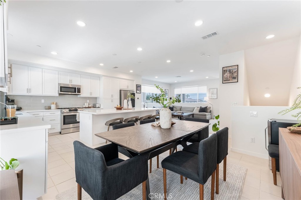 13161 Victory Boulevard Valley Glen, CA 91401 - Photo 15 of 33 a kitchen with a dining table chairs and microwave